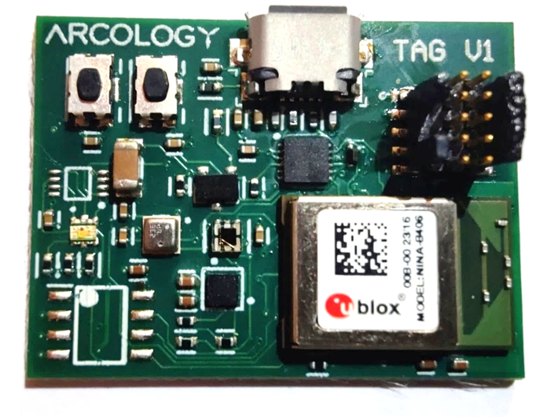 The multi-element Angle-of-Arrival locator: a large green antenna-array PCB with a grid of copper patches, mounted in a clear acrylic housing labelled UDP170, sitting on a desk.